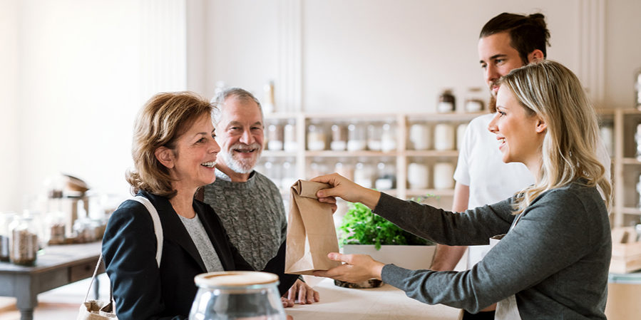 Senior Couple Buying Groceries In Zero Waste Shop, Sales Assista