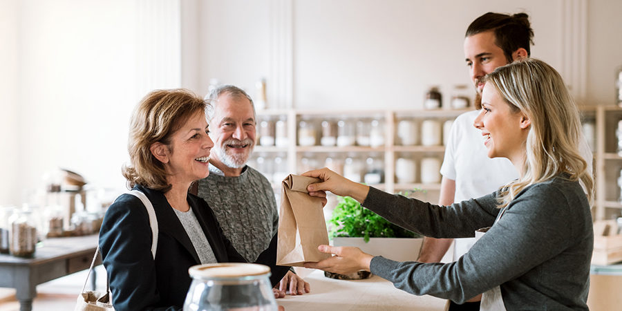 Senior Couple Buying Groceries In Zero Waste Shop, Sales Assista