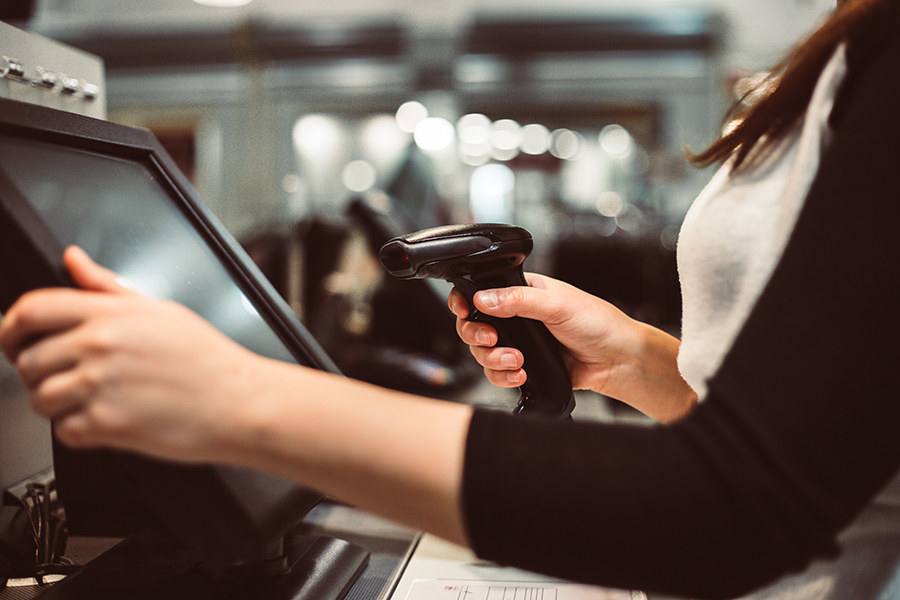 Young woman hand doing process payment on a touchscreen cash reg